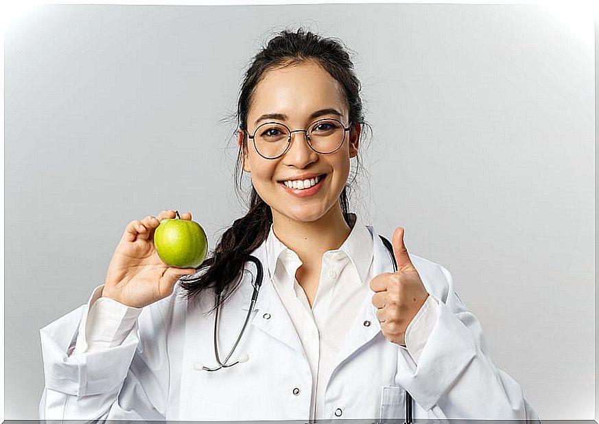 female doctor holding an apple.