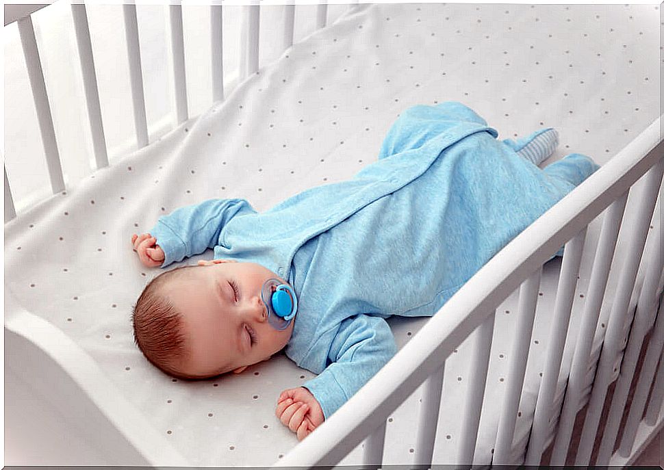 Baby sleeping in a clear crib with sleep myoclonus.