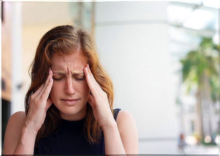 Woman with headache due to social anxiety.